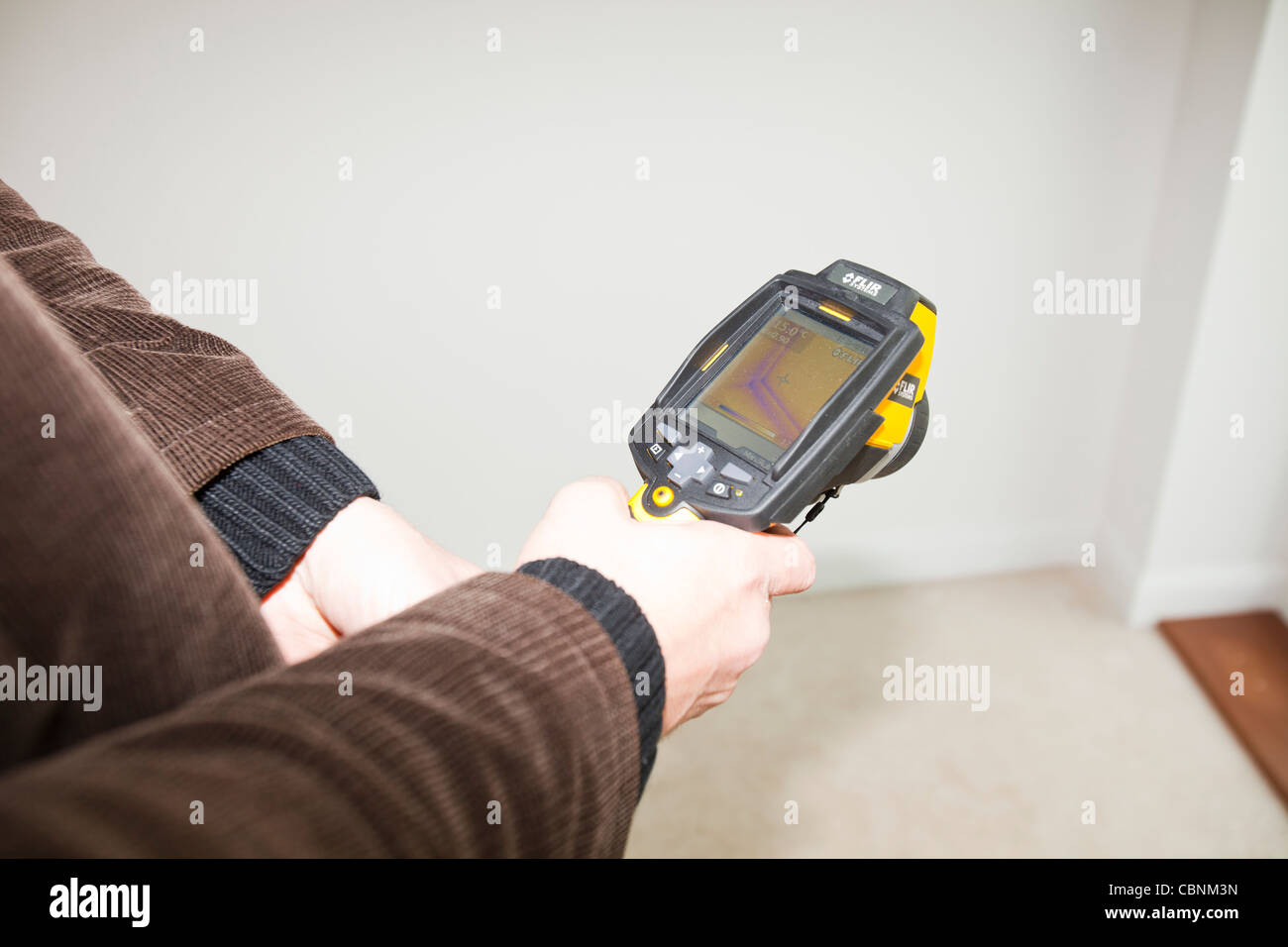 An architect uses a thermal imaging camera to test the thermal efficiency of a passivhaus in Sunderland, UK. Stock Photo