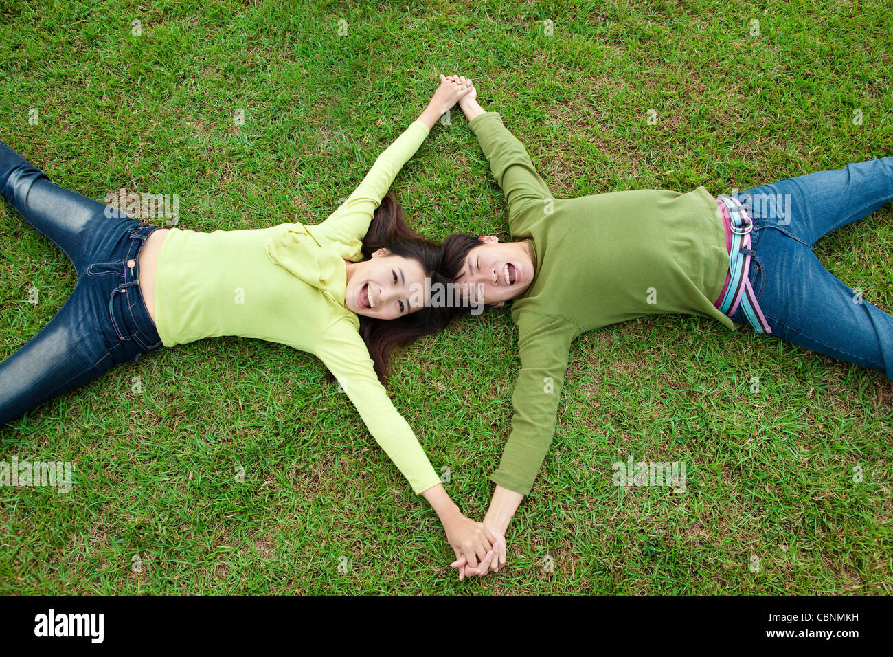 happy asian couple lying on the grass Stock Photo - Alamy