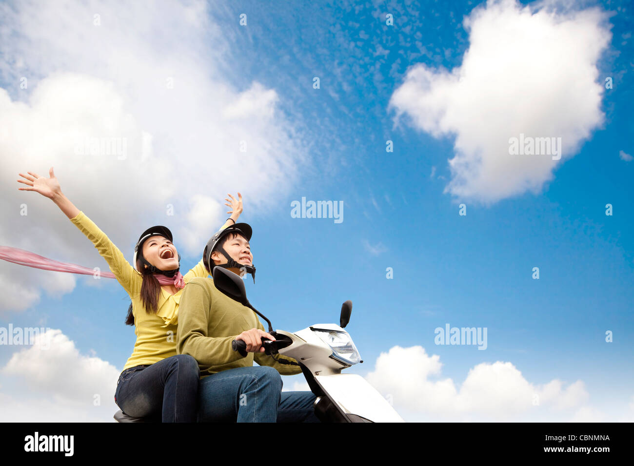 Happy young couple having fun on a scooter Stock Photo