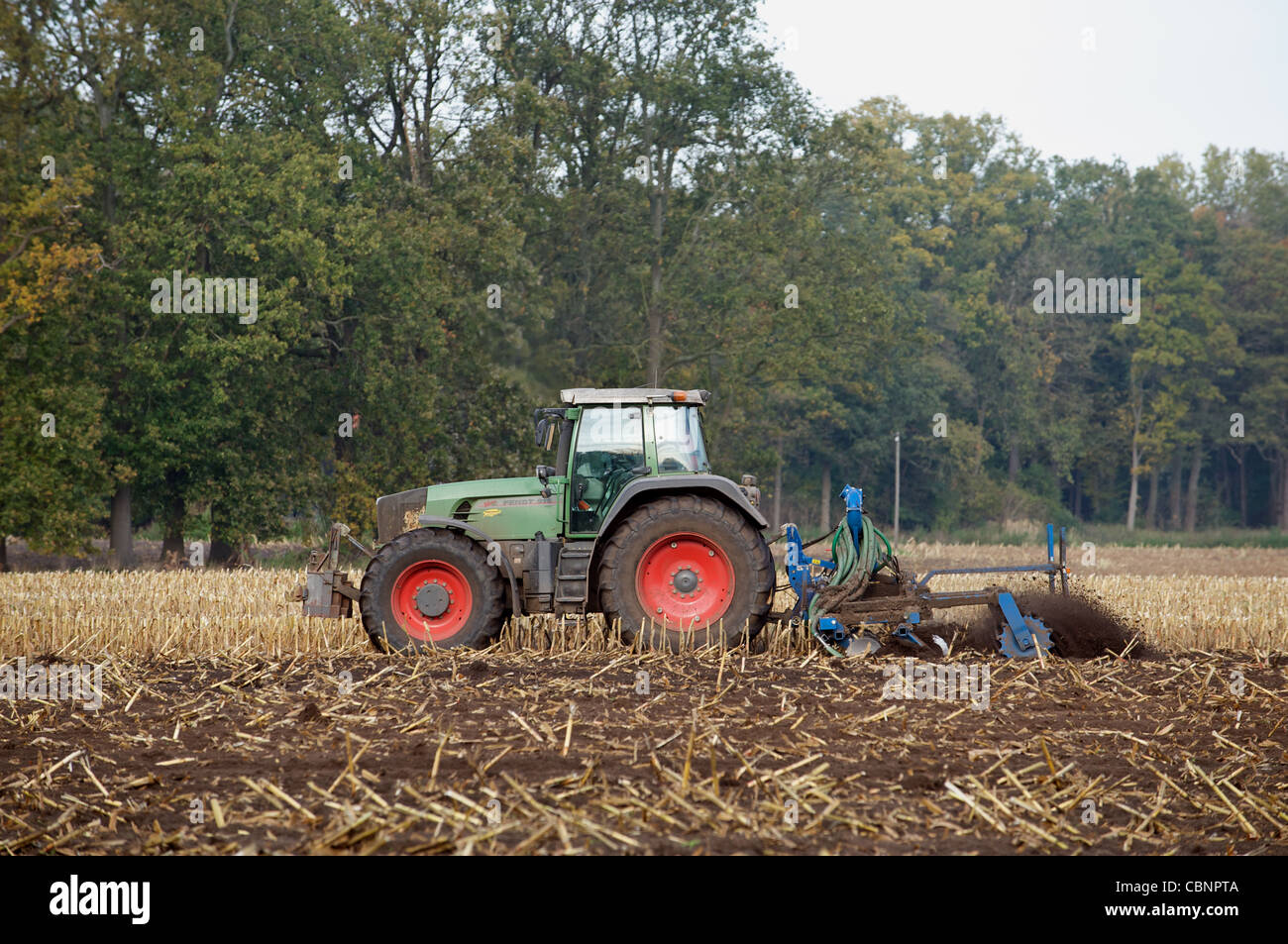 Farmer driving a German built Fendt tractor to cultivate a field, Strohen, Lower Saxony, Germany. Stock Photo