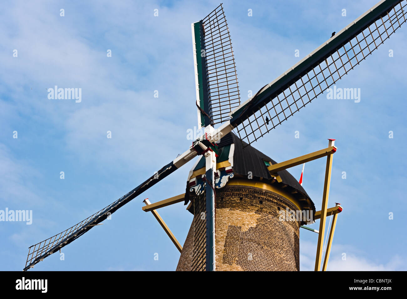 Blades of historic Dutch windmill still in use to grind corn with blue sky background Stock Photo