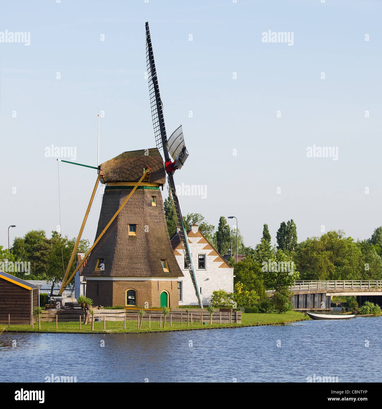 Dutch windmill, house and bridge at the waterside - square Stock Photo