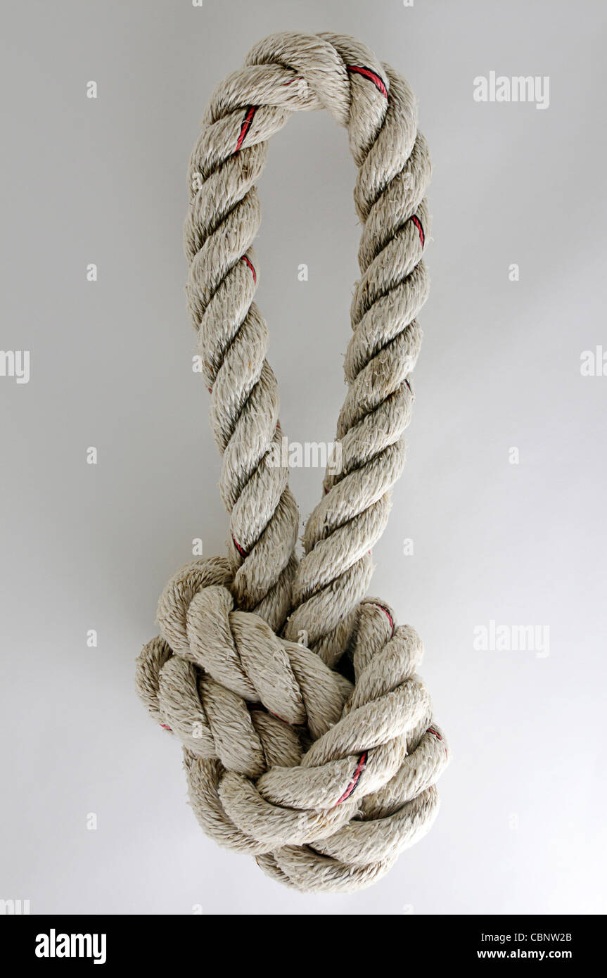 Loop of knotted, thick, neatly twisted, white marine rope. Stock Photo
