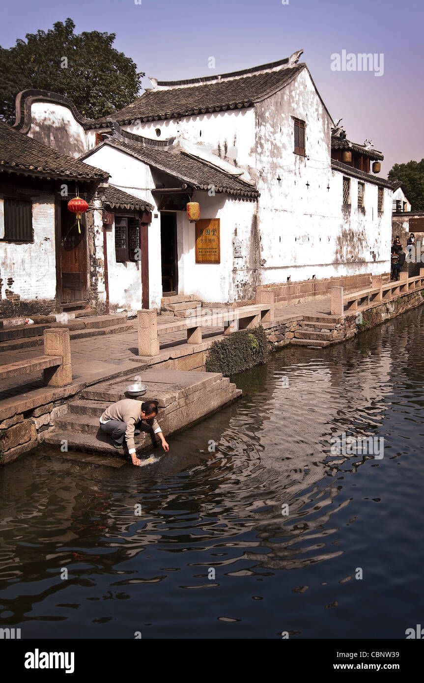 Man washing dishes in a canal at Zhouzhuang watertown near Shanghai - China Stock Photo