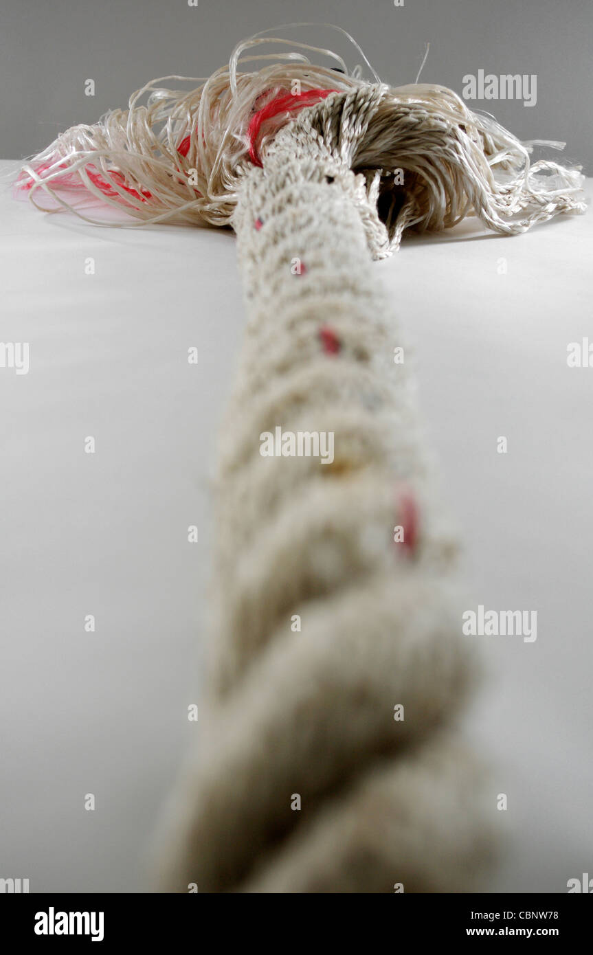 Closeup of neatly twisted multi-ply rope becoming undone at the end in the distance Stock Photo