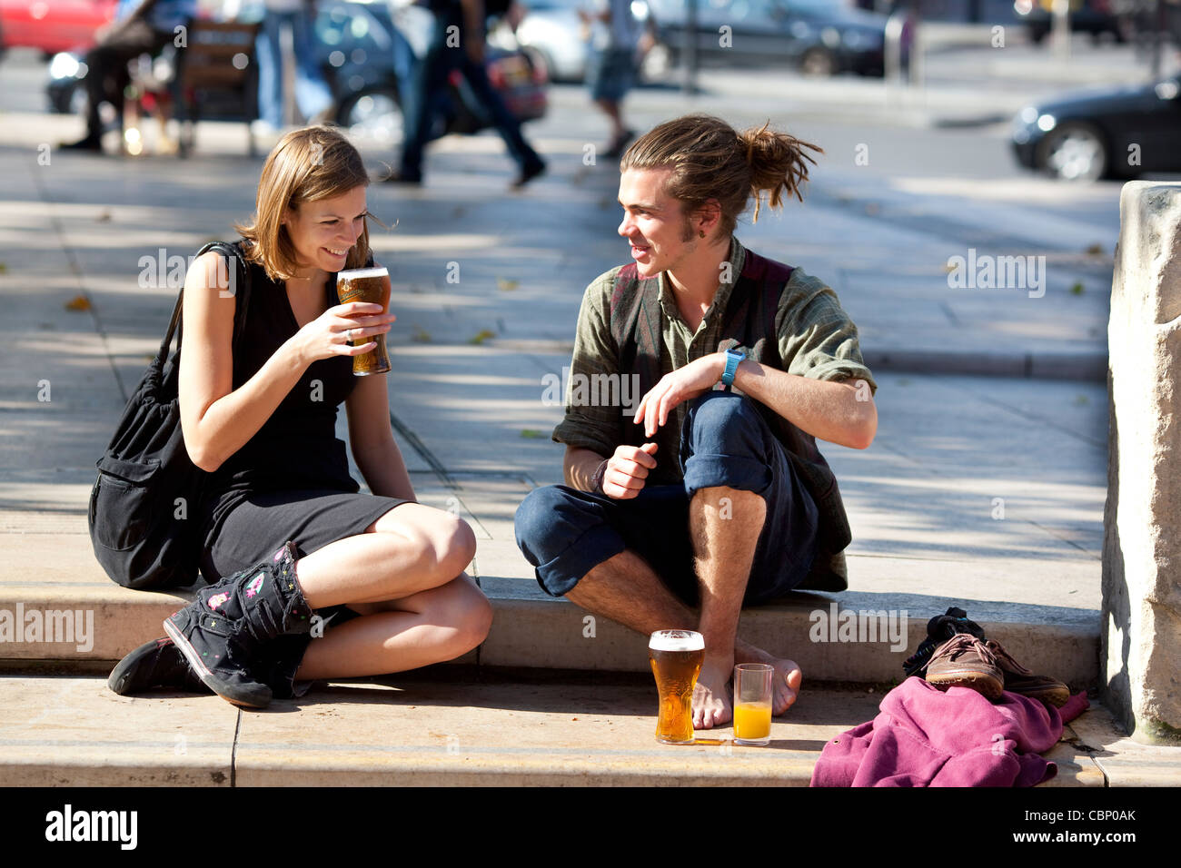A young couple drinking lager outside the Ritzy cinema in Brixton, London Stock Photo