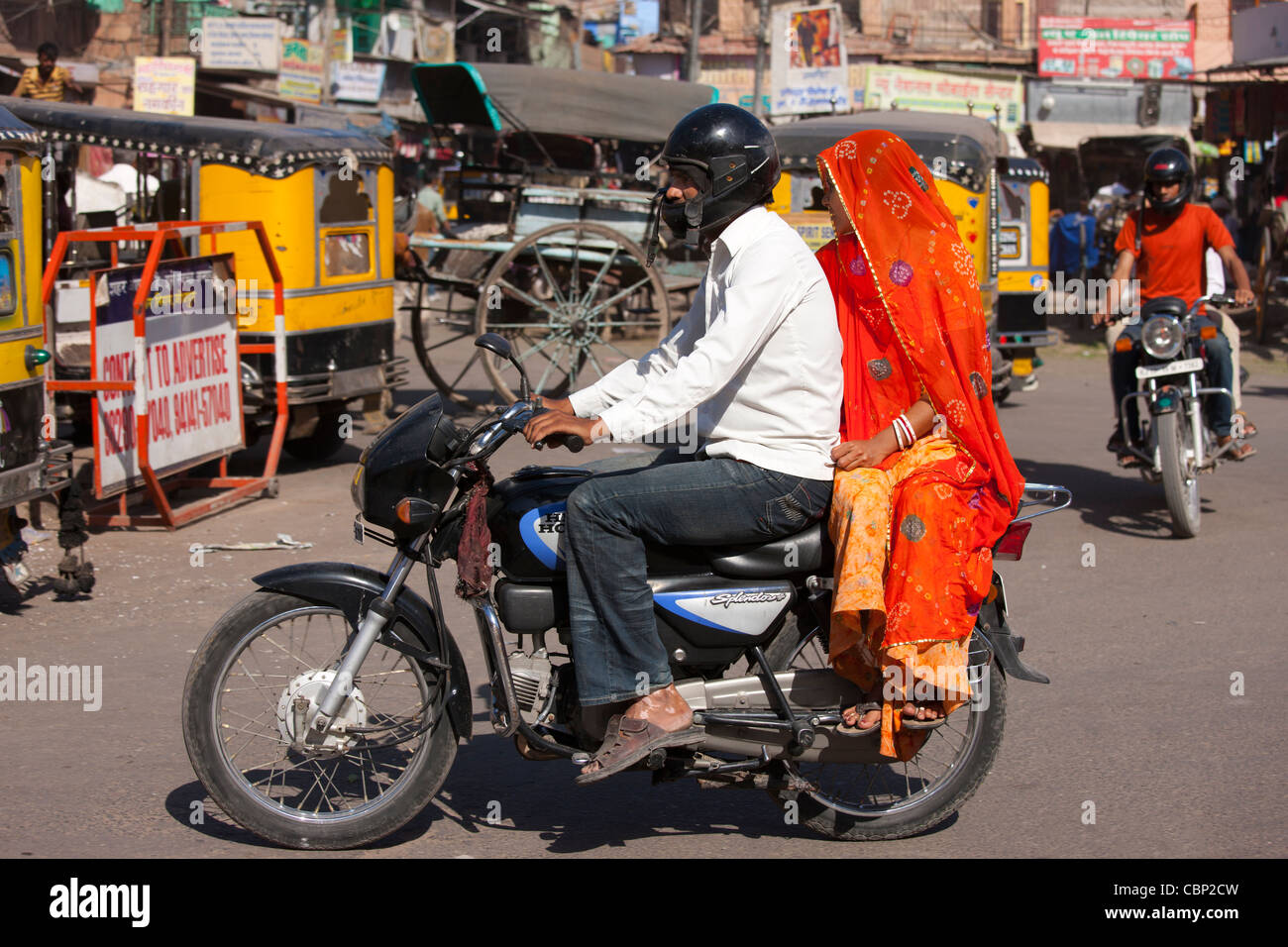 Indian couple riding motorcycle, street scene at Sardar Market at Girdikot, Jodhpur, Rajasthan, Northern India Stock Photo