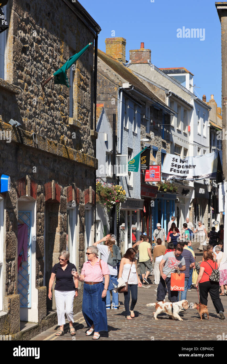 Shops on a narrow cobbled street busy with tourists in St Ives, Cornwall, England, UK, Britain. Stock Photo
