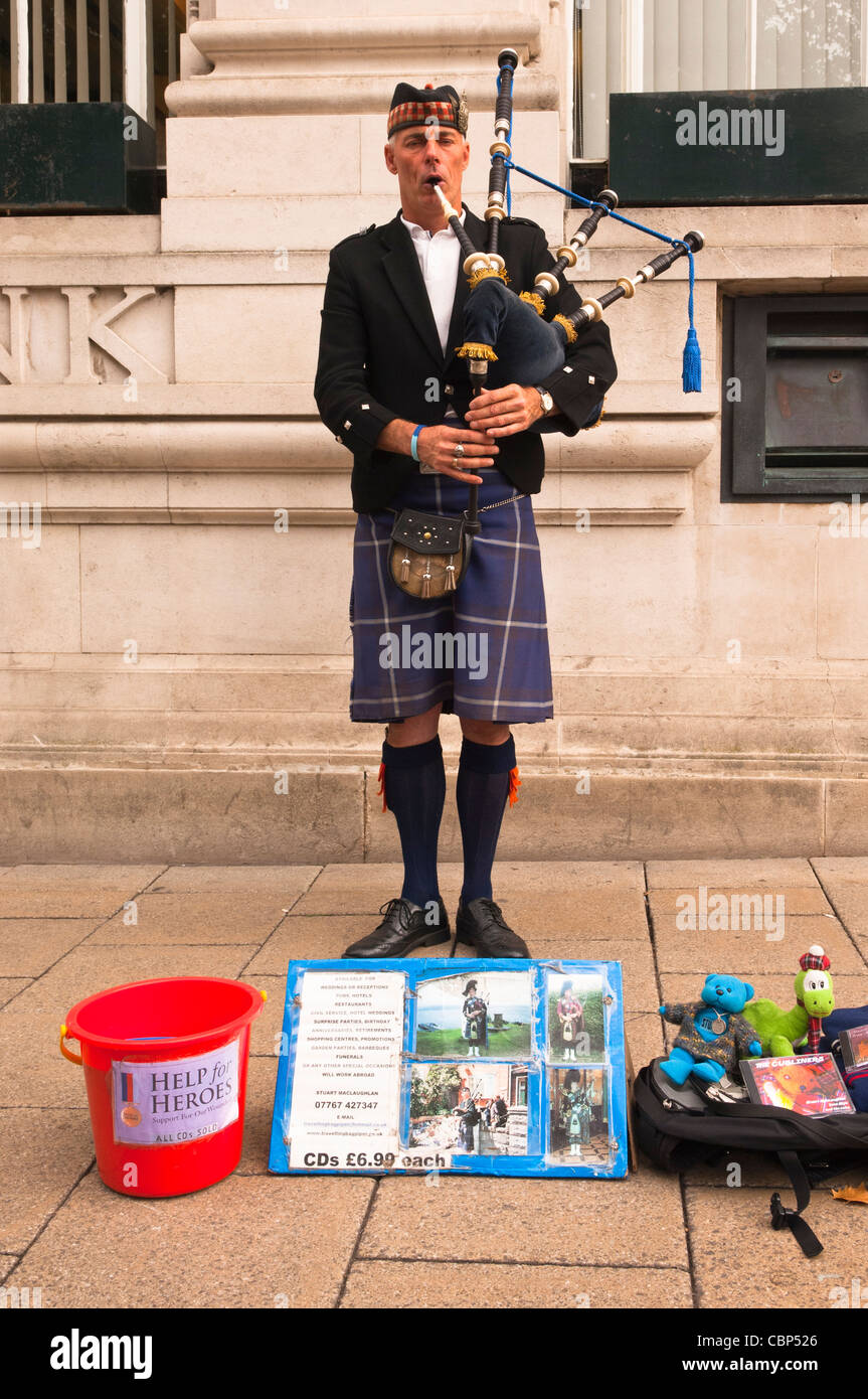 A busker playing the bagpipes in Norwich , Norfolk , England , Britain , Uk Stock Photo