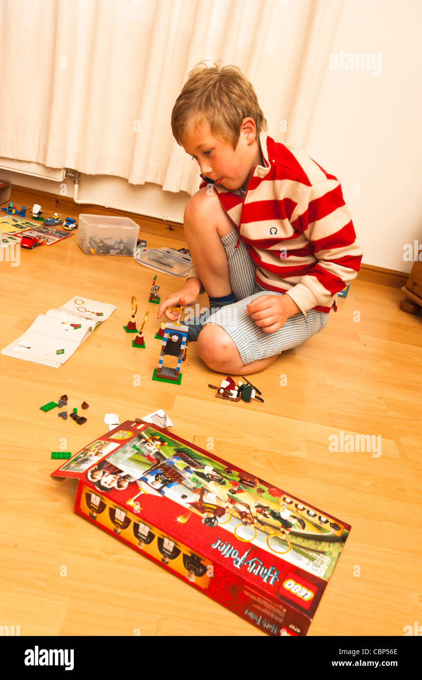 An eight year old boy building and playing with his Lego Harry Potter set in the Uk Stock Photo