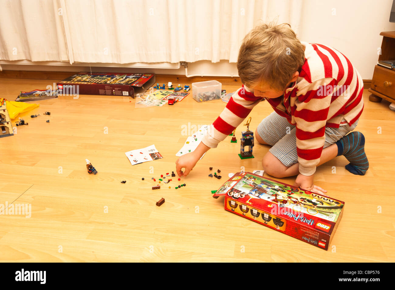 An eight year old boy building and playing with his Lego Harry Potter set in the Uk Stock Photo