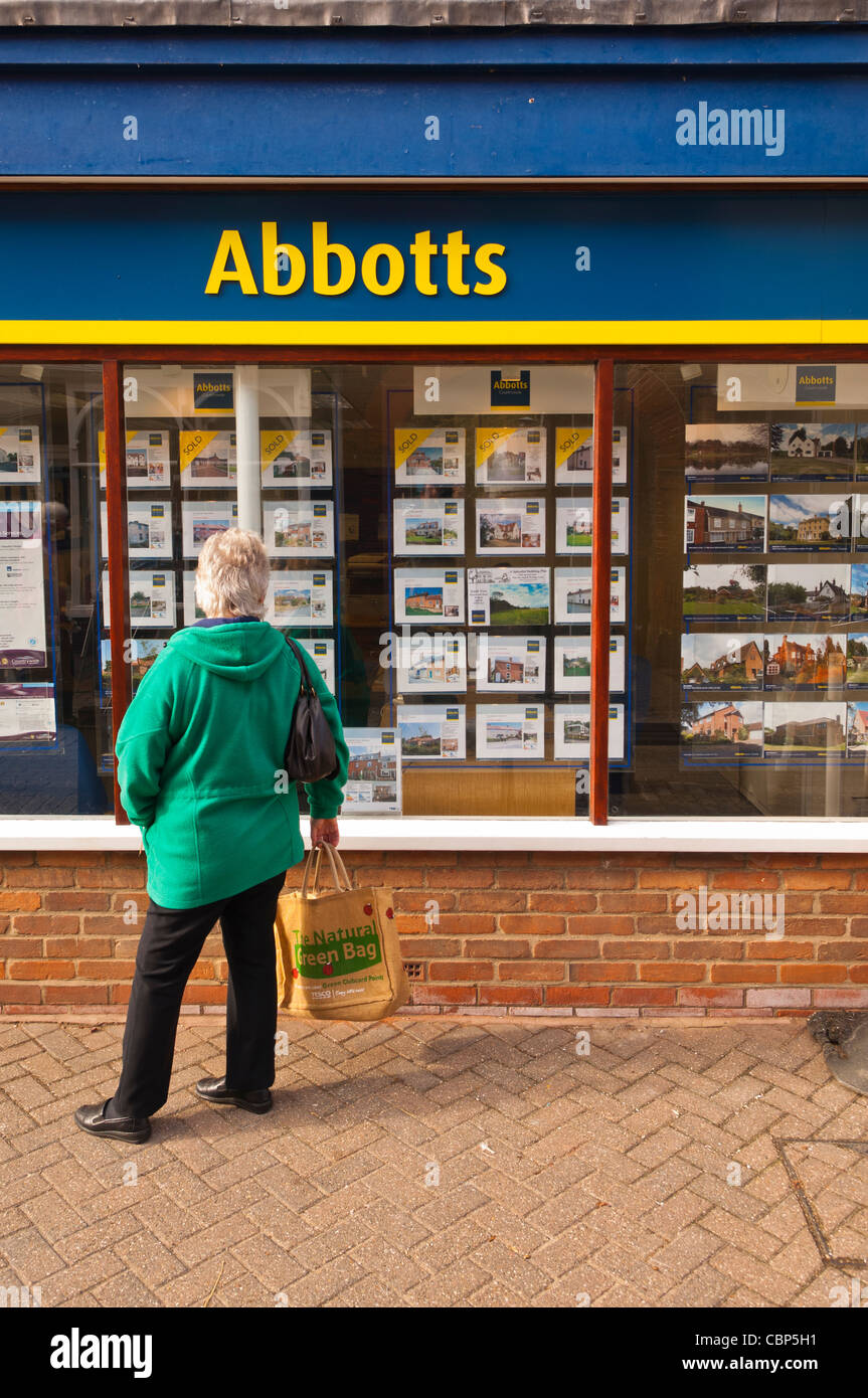 The Abbotts estate agent with a woman looking in the window in