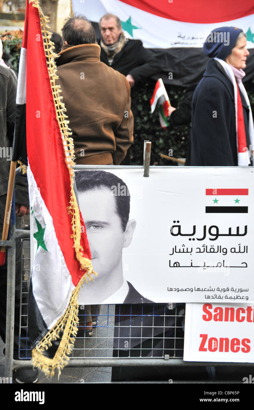 Bashar al-Assad President Assad of Syria poster and flag at an anti Assad protest outside the American Embassy London Stock Photo
