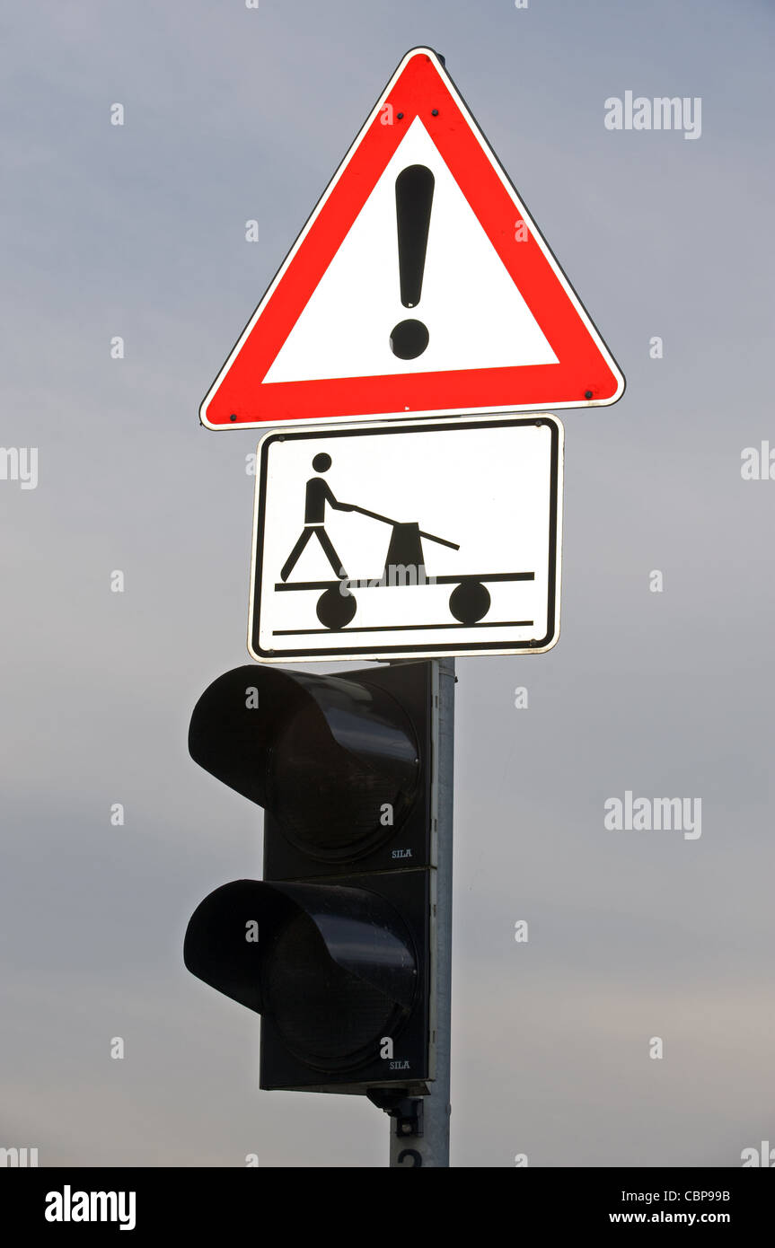 Road traffic sign and traffic lights at a railway level crossing in Germany Stock Photo