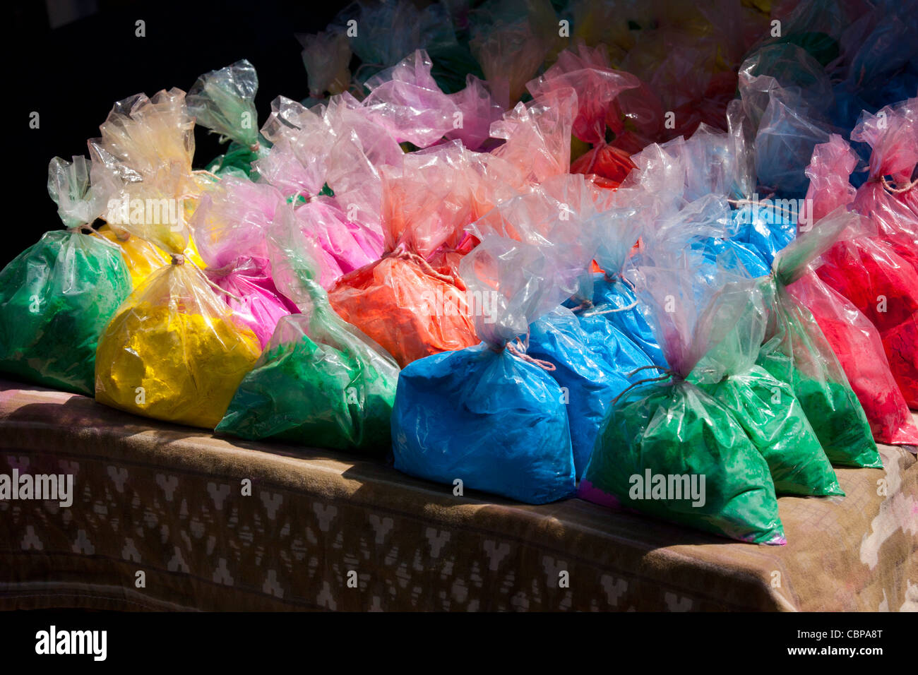 Bags of powder colours for traditional Hindu Holi festival on sale at market stall in old town Udaipur, Rajasthan, Western India Stock Photo