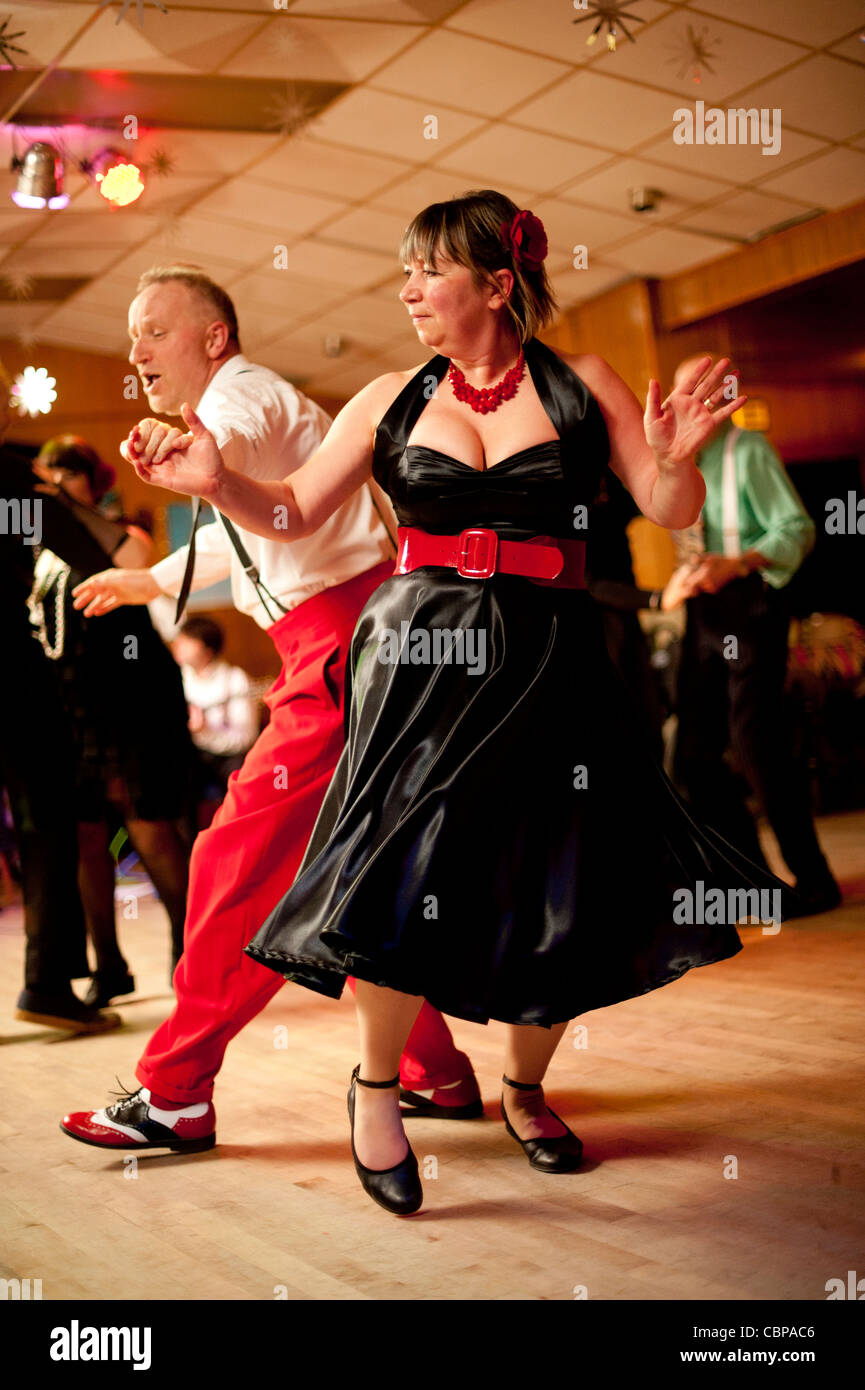 People swing dancing Lindy hopping and jiving to retro 40s 50s music at a club, UK Stock Photo