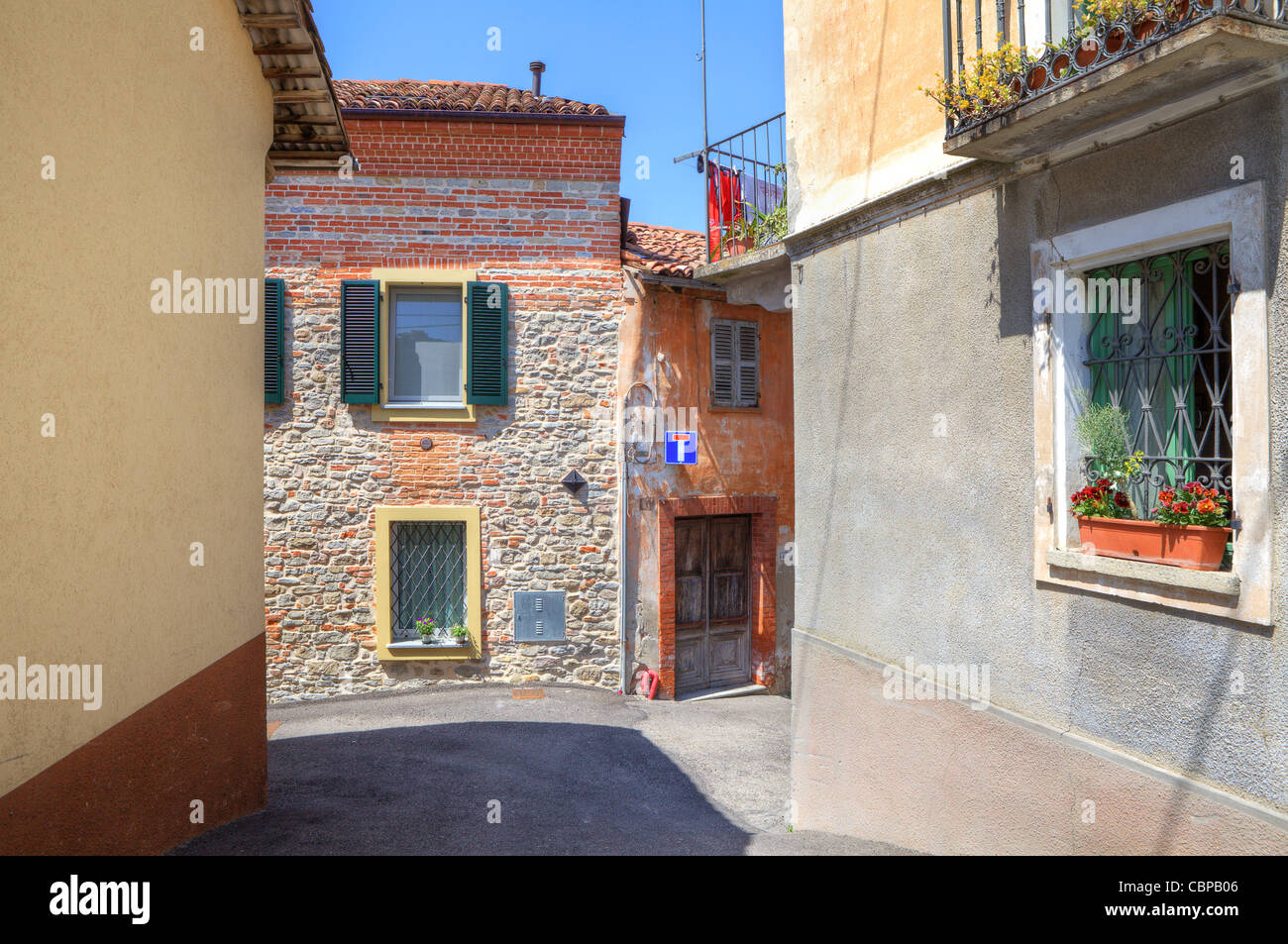 Old brick house on narrow street among new houses in town of Diano D'Alba in Piedmont, northern Italy. Stock Photo