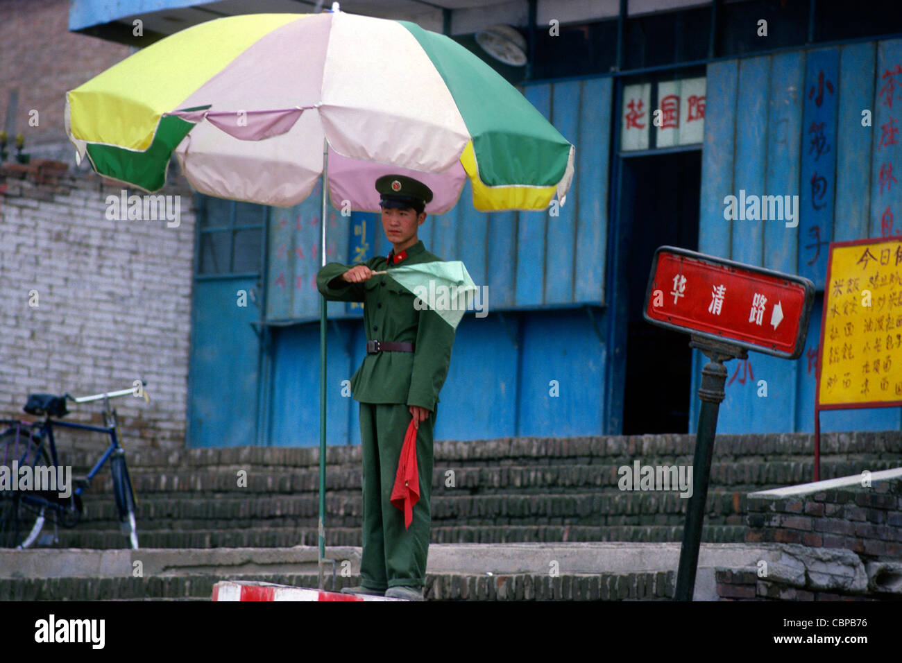 Railway guard under umbrella Xian Shaanxi China Stock Photo