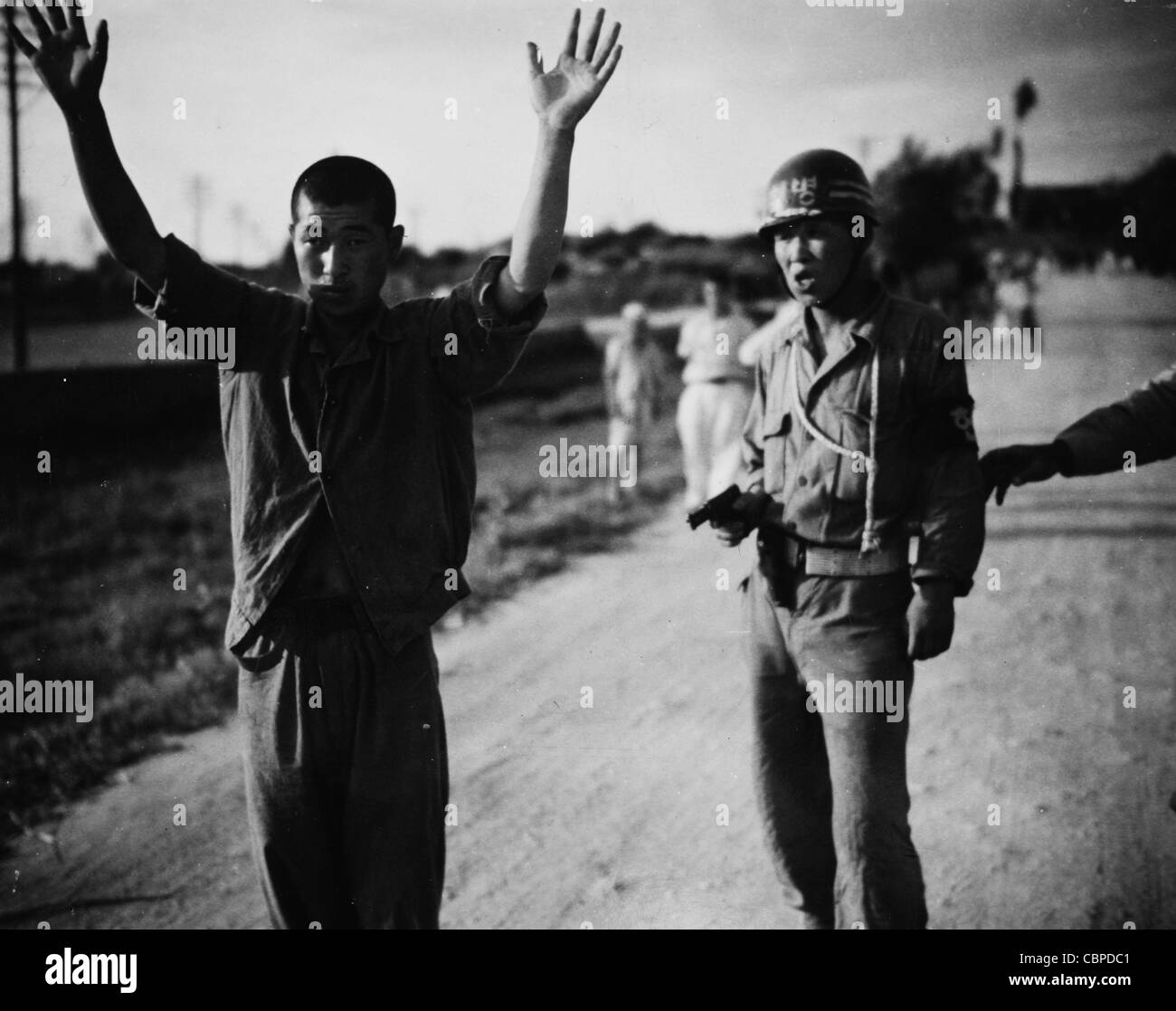 Korea 5 July 1950: A South Korean military policeman marches a North Korean prisoner of war to the stockage somewhere in souther Stock Photo
