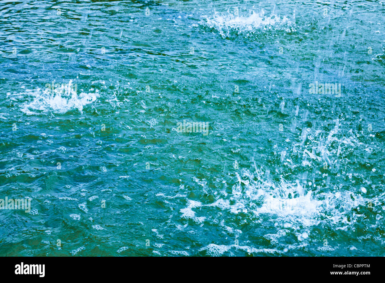 Water splashes background. A pool of blue water with more water splashing into it. Stock Photo