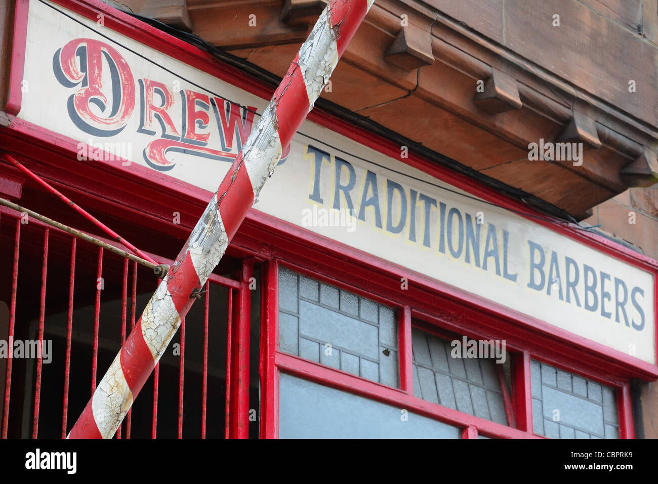 Red and white stripped pole of a traditional barbers shop. Stock Photo
