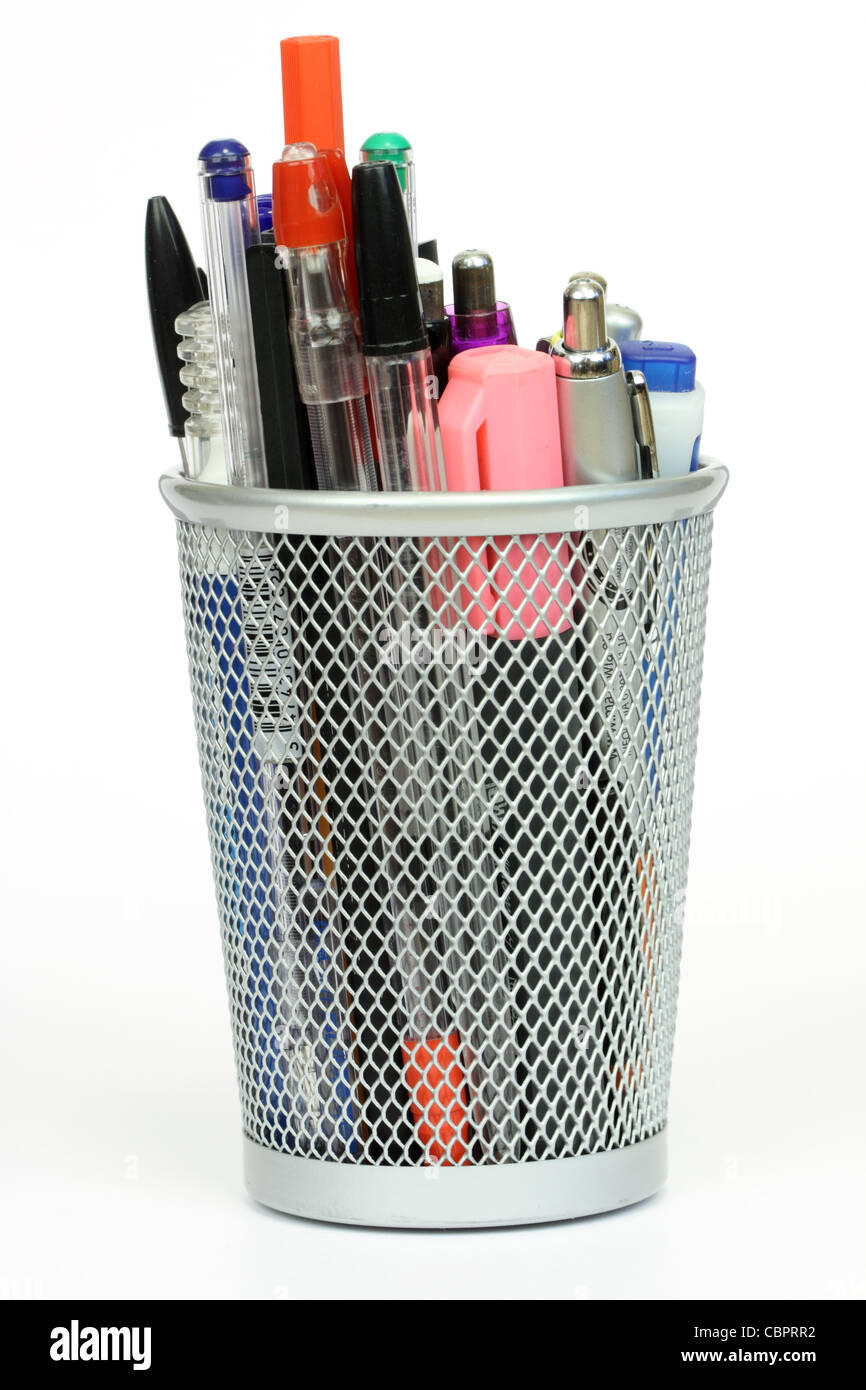 silver mesh desk cup full of pens and writing utensils Stock Photo