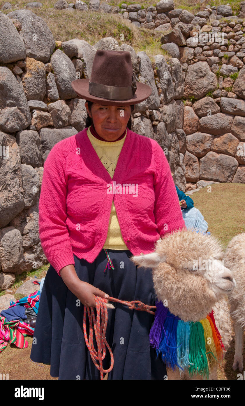 Traditional woman with colorful clothes and llamas in religious region