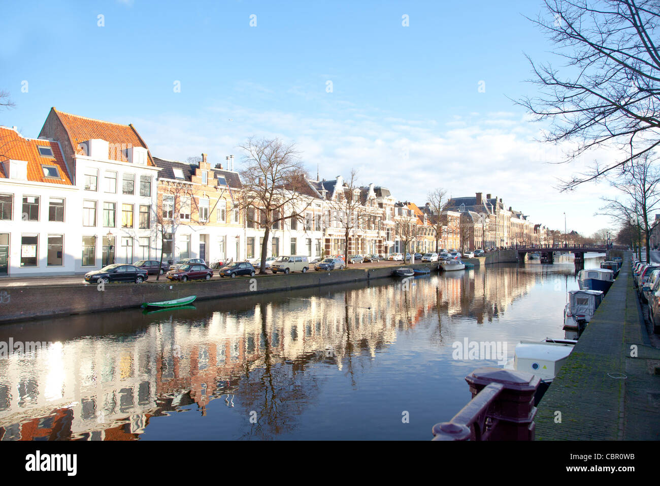 Dutch canal with old houses and boats with blue sky Stock Photo