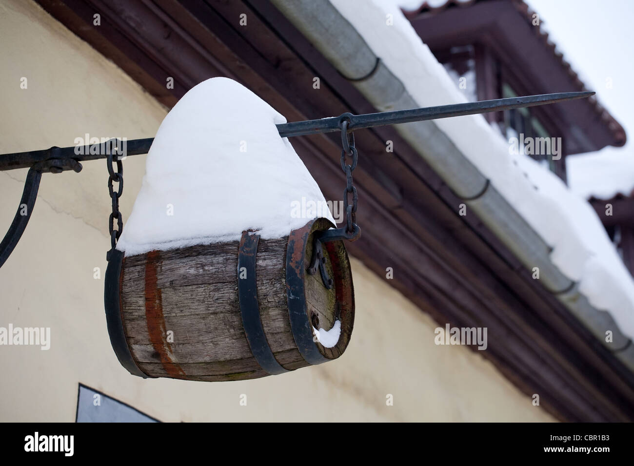 small wine keg with big snowdrift hanging on house wall Stock Photo Alamy