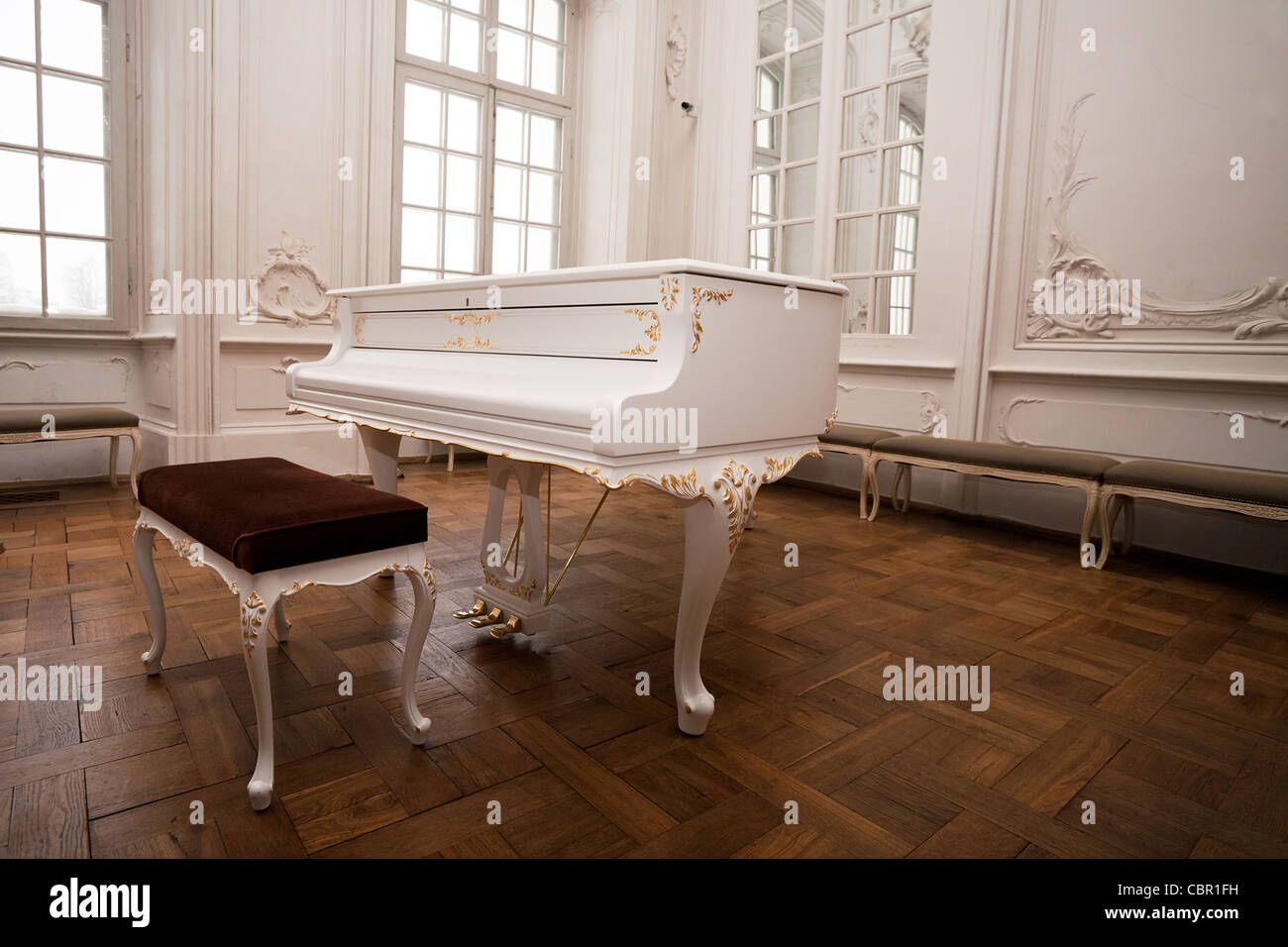 white grand piano standing in elegant white interior of palace hall Stock Photo