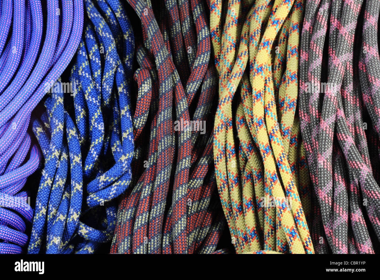 multi-colored old used rock climbing ropes in bundles Stock Photo