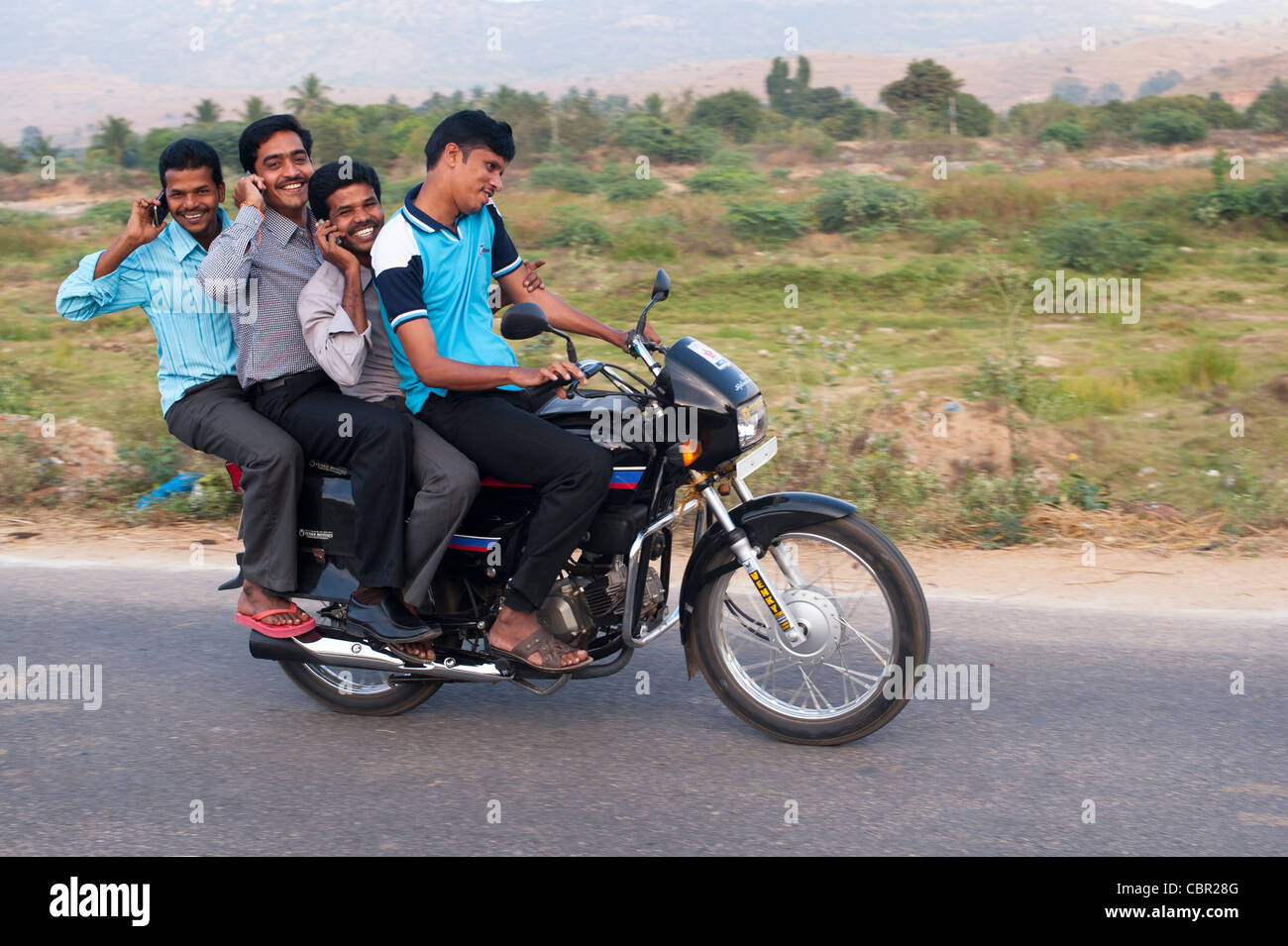 https://c8.alamy.com/comp/CBR28G/four-indian-men-on-a-motorcycle-on-their-mobile-phones-andhra-pradesh-CBR28G.jpg