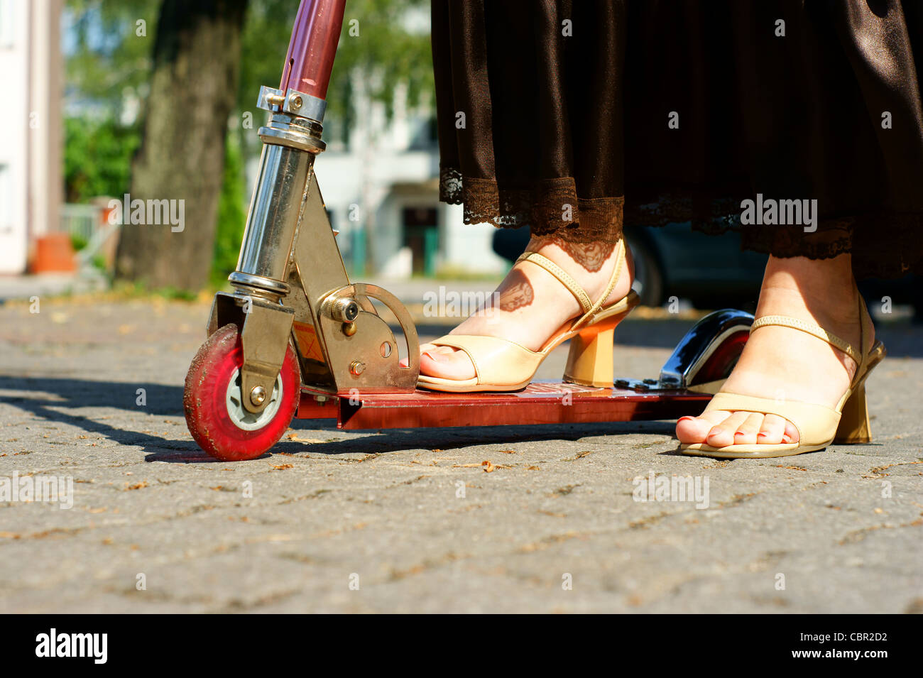 Foot Riding Away Woman foot ride a scooter on brown skirt Stock Photo - Alamy