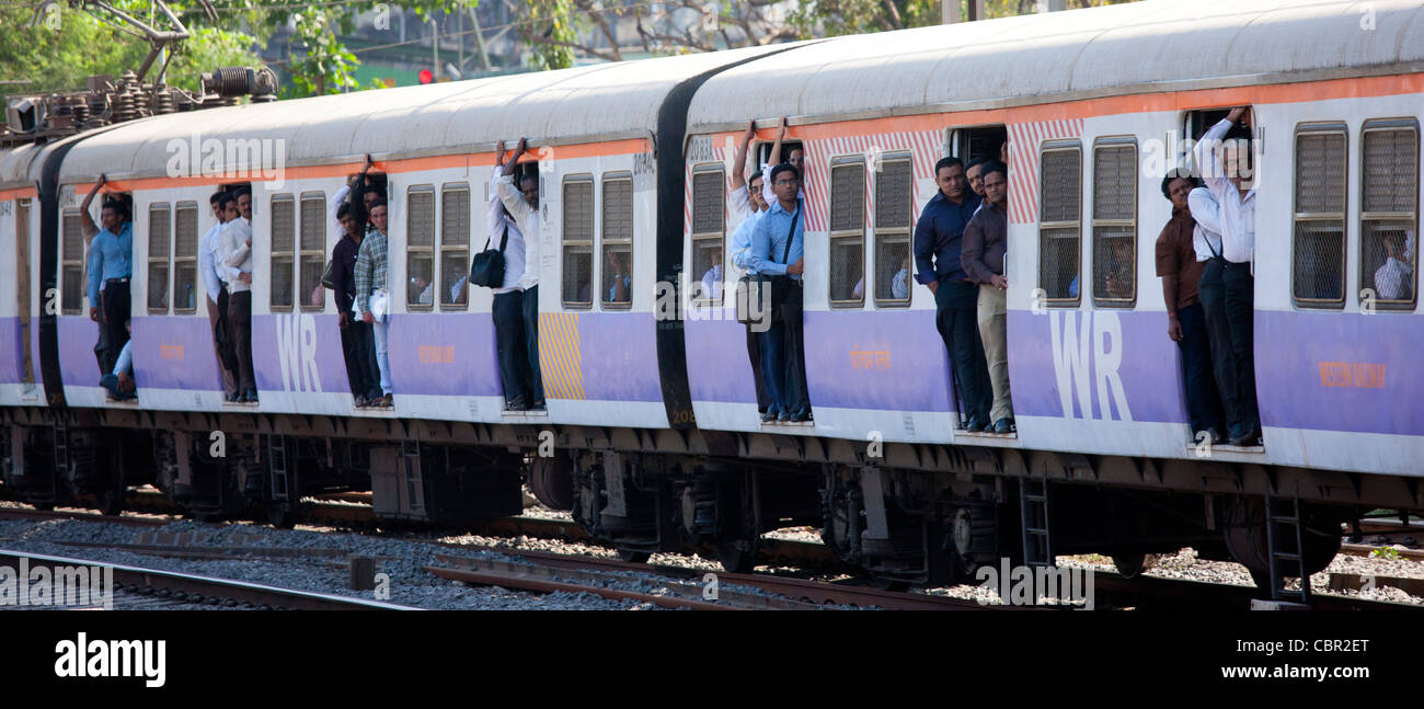 Office workers on crowded commuter train of Western Railway near Mahalaxmi Station on the Mumbai Suburban Railway, India Stock Photo