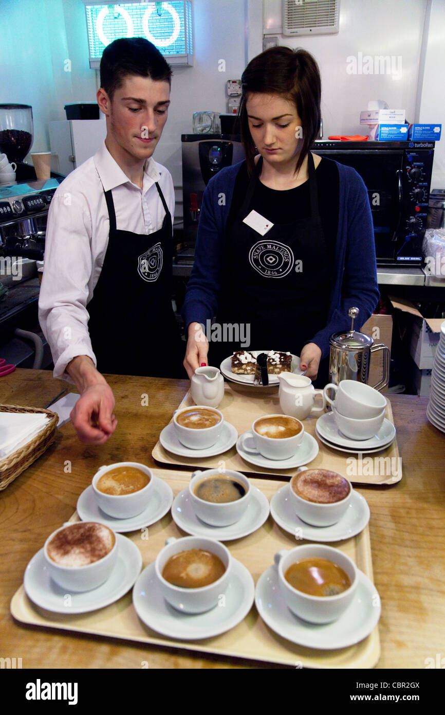 Waiter waitress serving; Staff serving coffee, Snape Maltings cafe shop, Suffolk UK Stock Photo