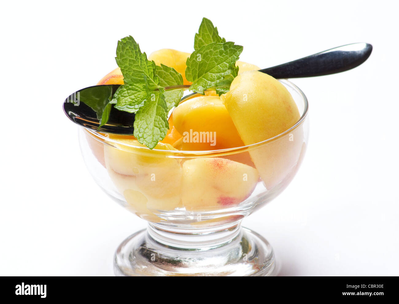 Sliced peaches and sprig of mint Stock Photo