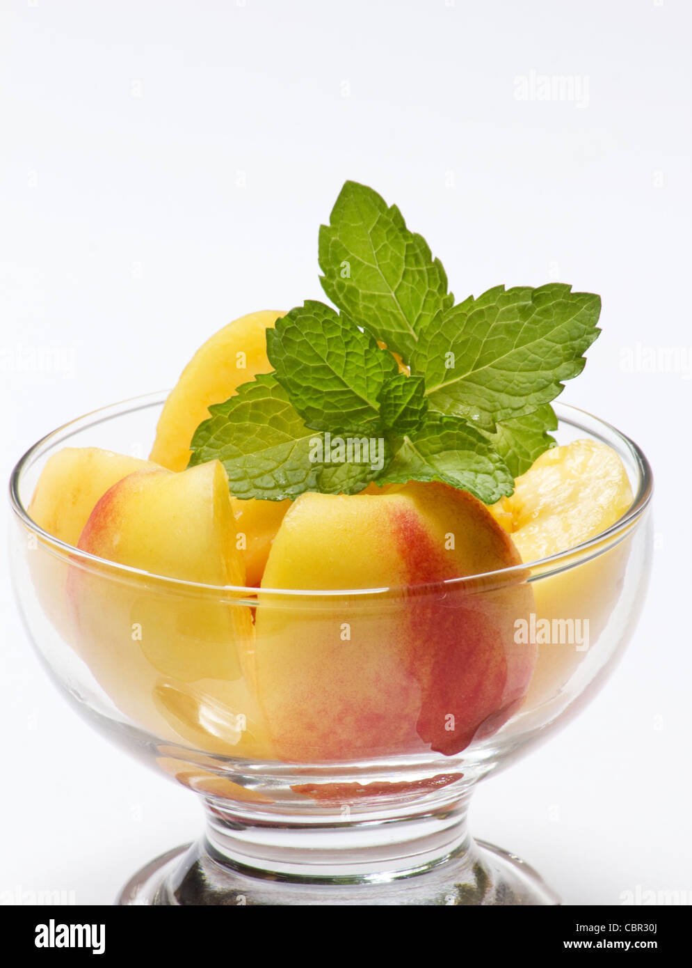Sliced peaches and sprig of mint Stock Photo