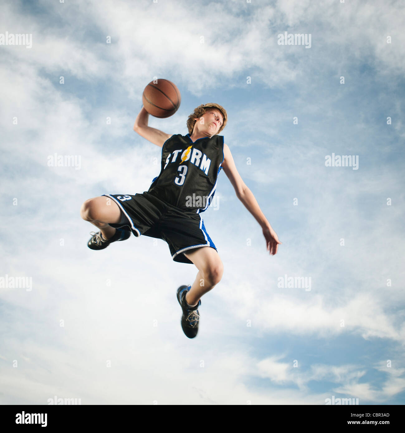 Caucasian teenager playing basketball Stock Photo