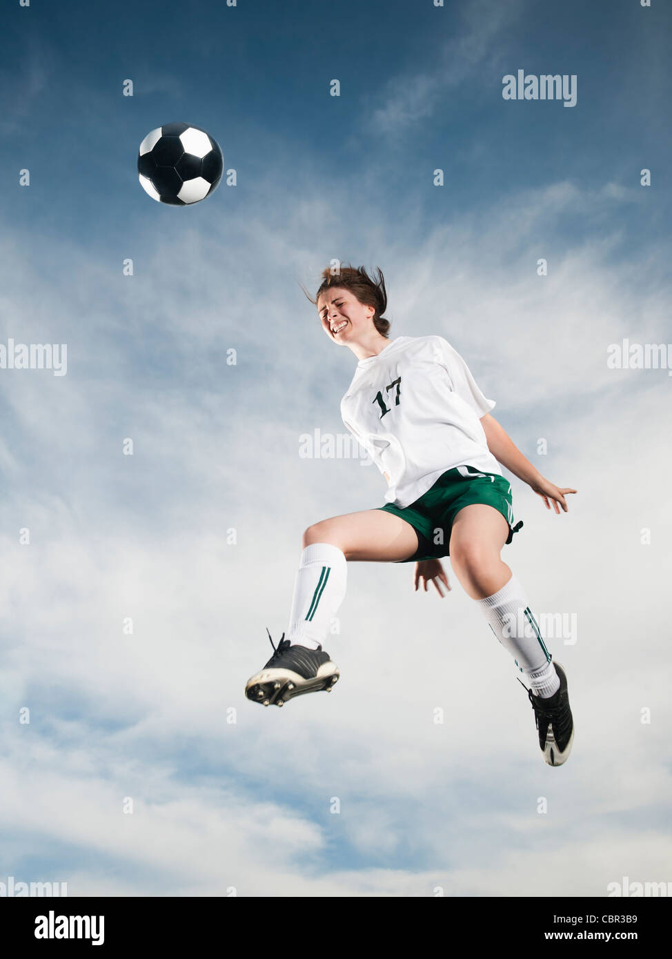 Caucasian teenager heading soccer ball in midair Stock Photo Alamy