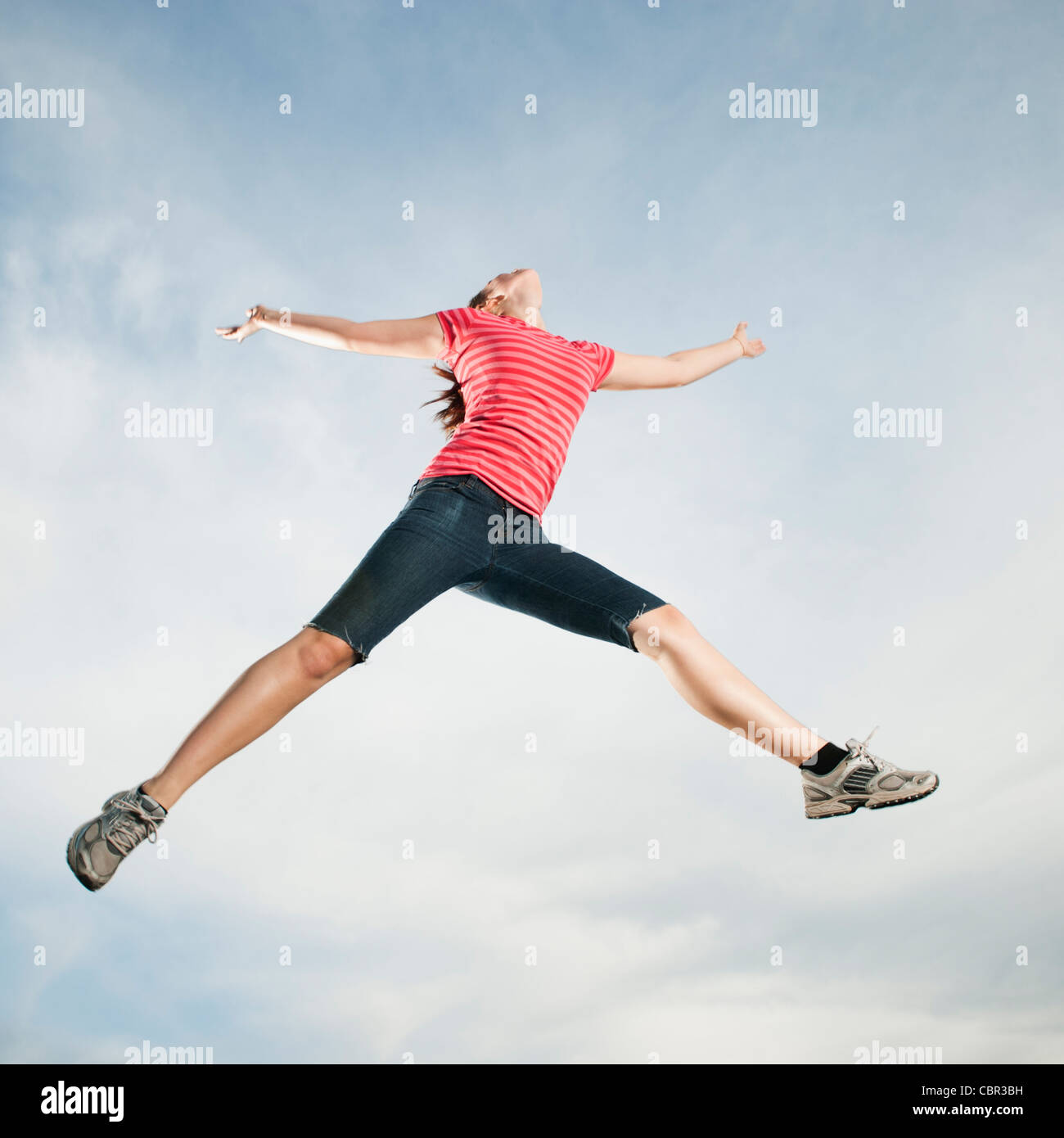 Caucasian teenager jumping in air Stock Photo