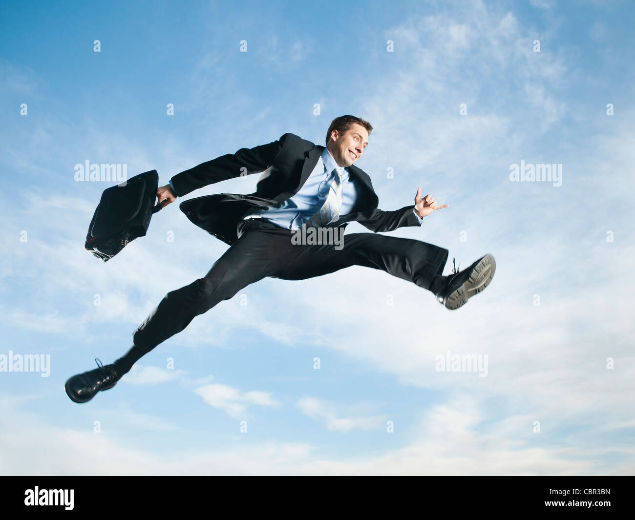 Caucasian businessman jumping in air Stock Photo