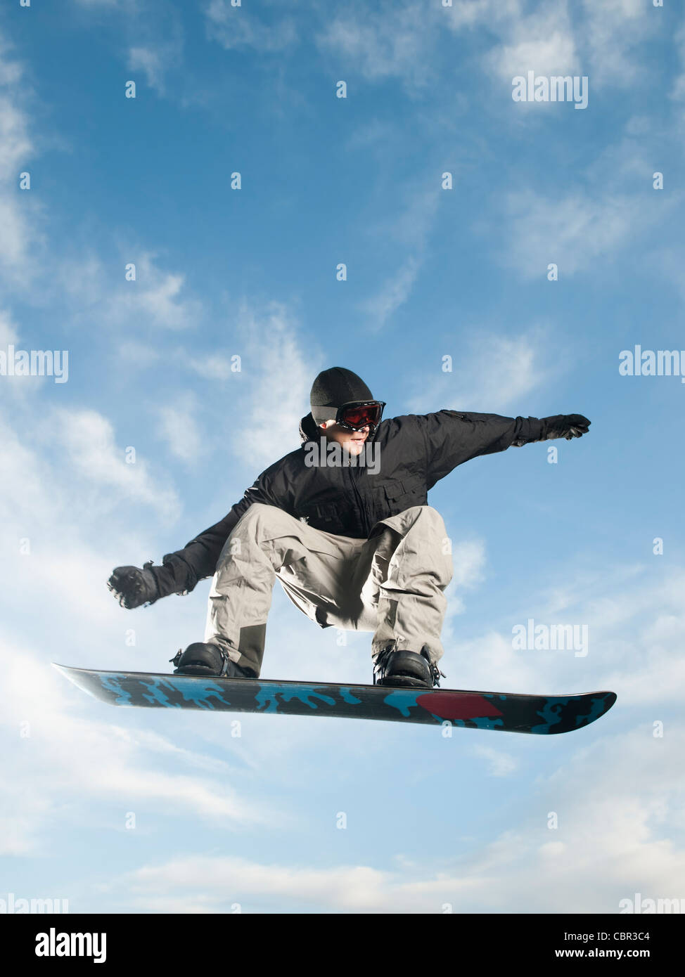 Caucasian man on snowboard in mid-air Stock Photo