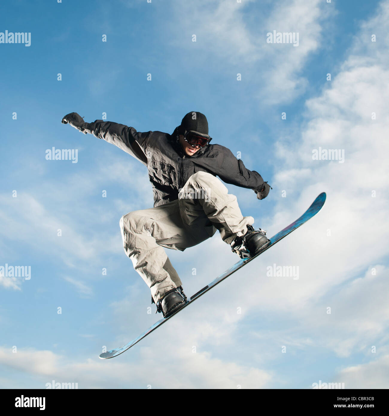 Caucasian man on snowboard in mid-air Stock Photo