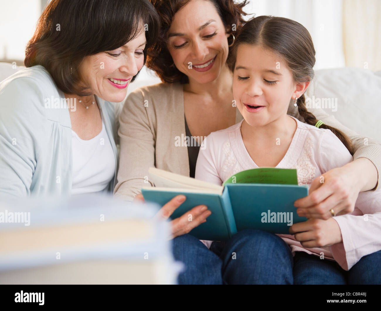 Family reading book together Stock Photo
