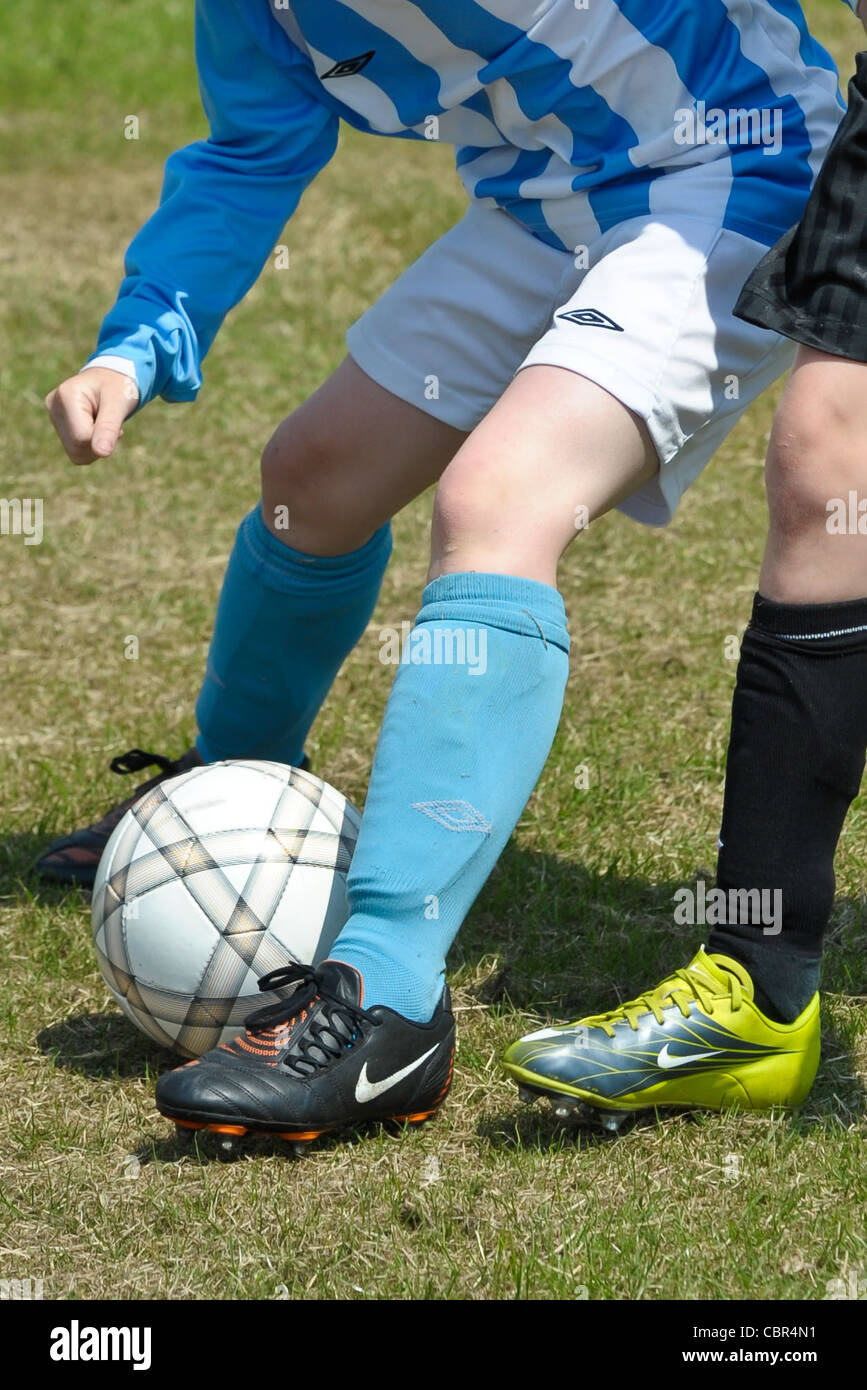 A cropped generic image of a soccer player showing the ball at the players feet. Stock Photo