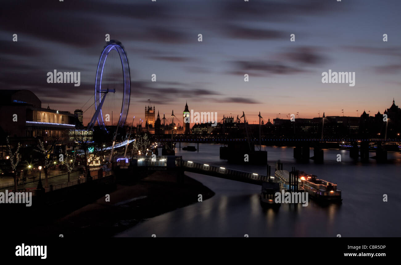 View of Big Ben, houses of parliament and Millenium wheel from Waterloo Bridge at sunset. Stock Photo