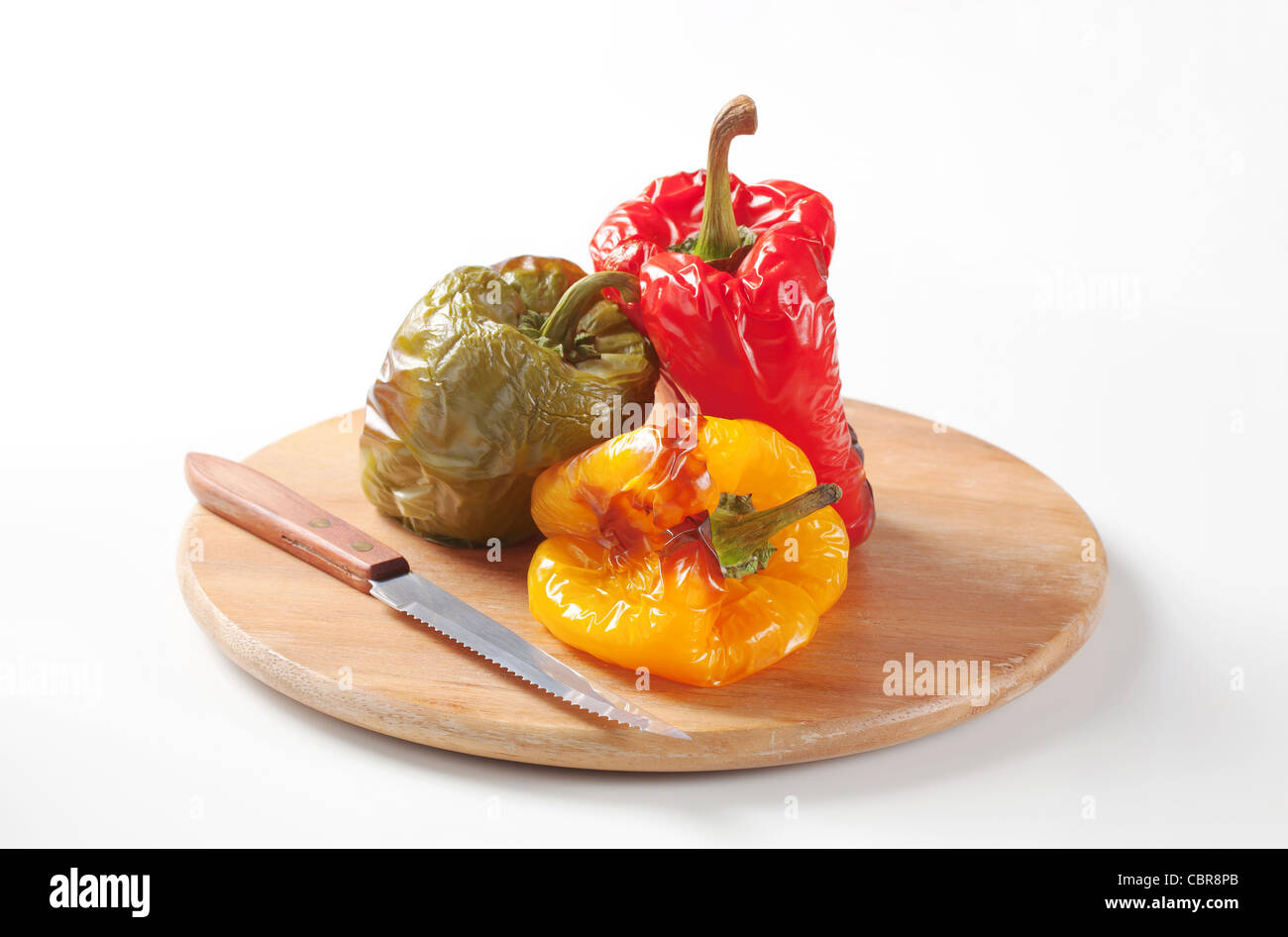 Three roasted bell peppers on a cutting board Stock Photo - Alamy