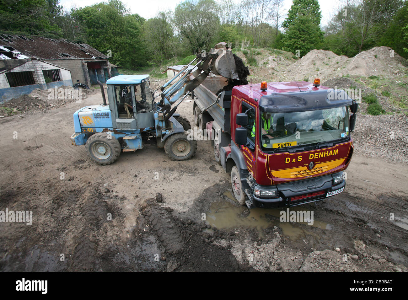Digger loading a tipper truck/ lorry with soil Stock Photo