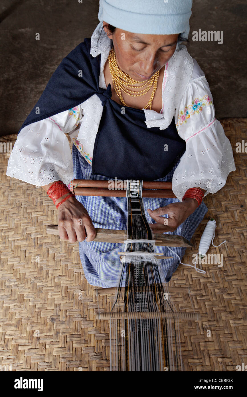 Indigenous woman weaving a traditional belt in a village near Otavalo, Ecuador. Stock Photo