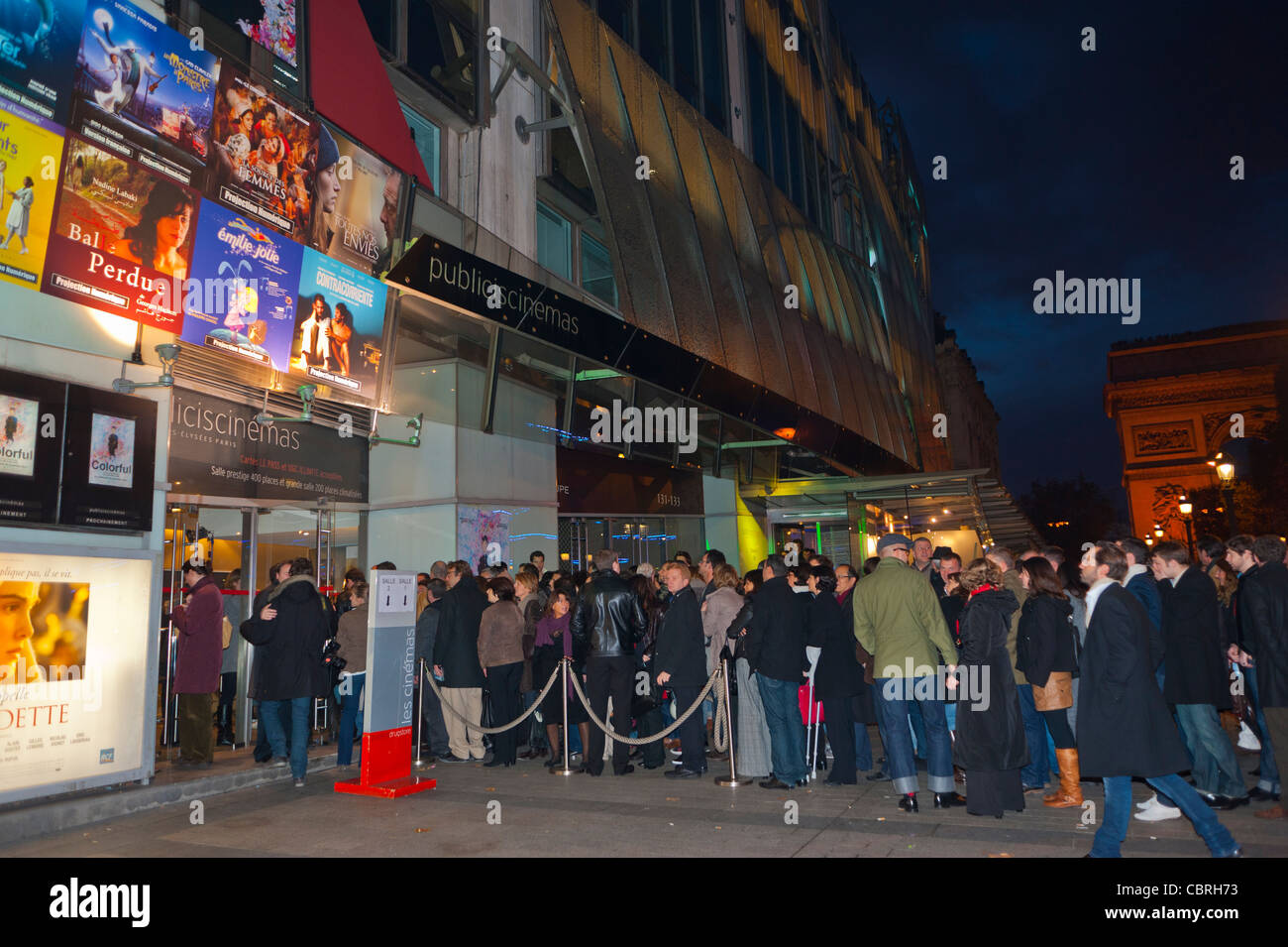 Paris Champs ELysees, France, People Queuing, Standing on Line, in front of French Cinema Movie Theatre, at Night  'Drugstore Publicis', waiting lining up outside cinema Stock Photo